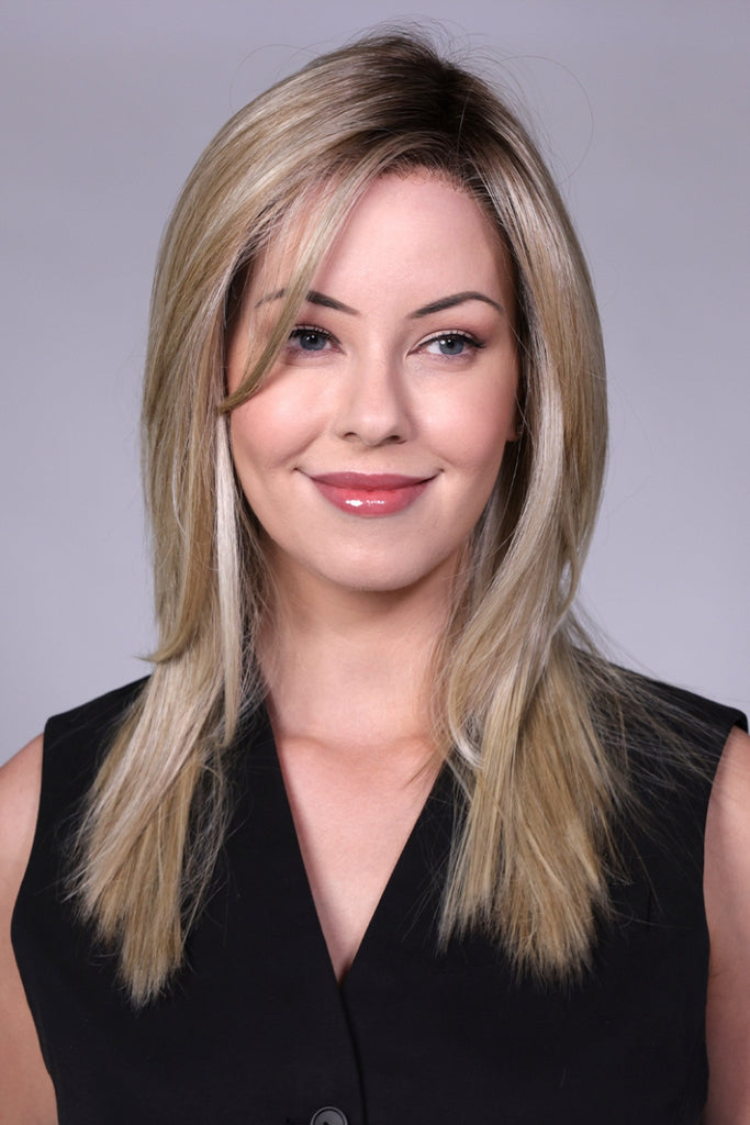 Front view of woman wearing blend of warm light blonde and ivory silk blonde with a dark brown root wig.