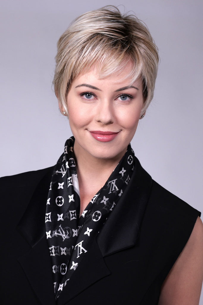 Woman wearing a short tapered pixie cut wig with bangs.