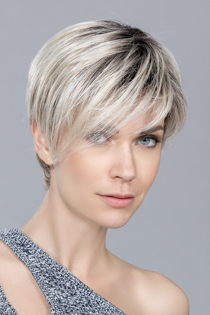 Model styling a short pixie cut wig.