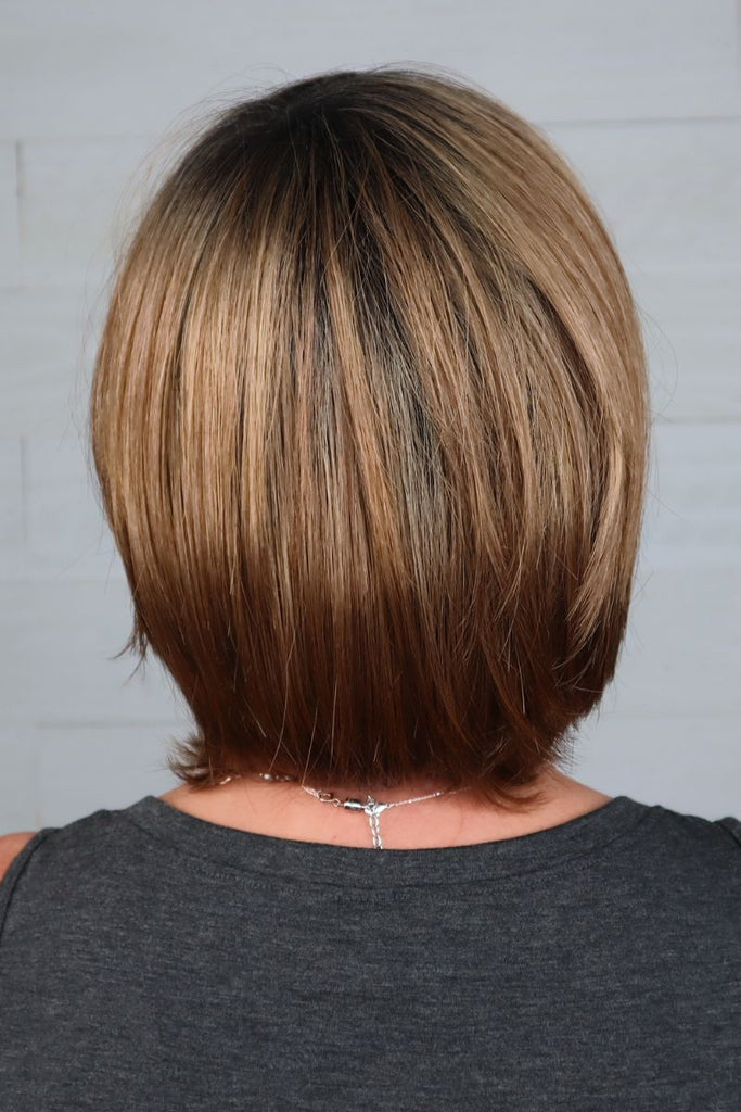 Model styling a short straight bob wig.