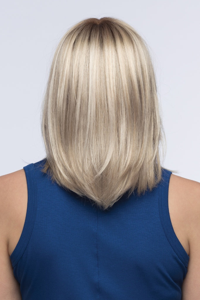 Back view of woman wearing a soft blend of sandy blonde, light blonde and iced blonde with a light golden brown root.