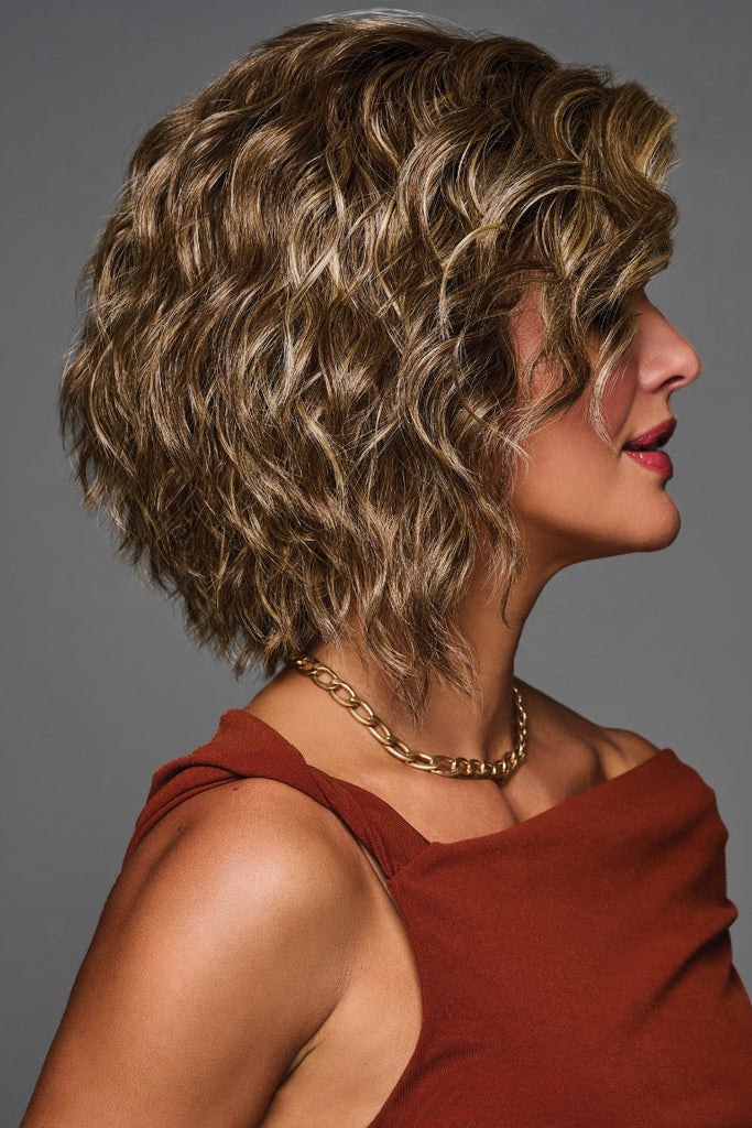 Side view of a woman wearing a chestnut brown wig highlighted with golden brown tones.