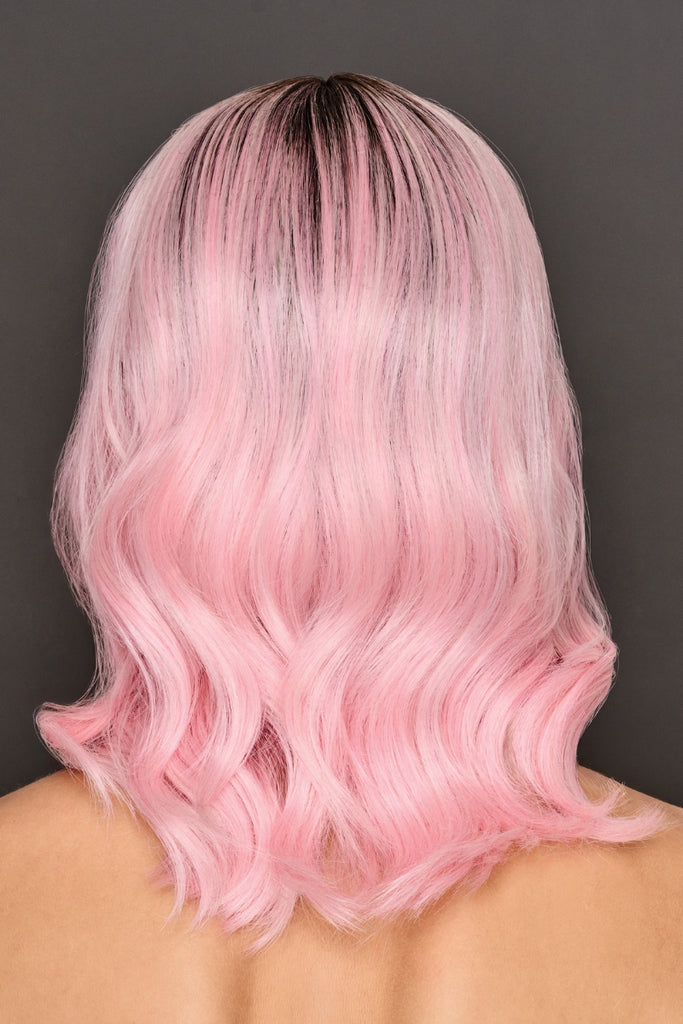 Back of model wearing a light pink, rooted wig with wavy layers.