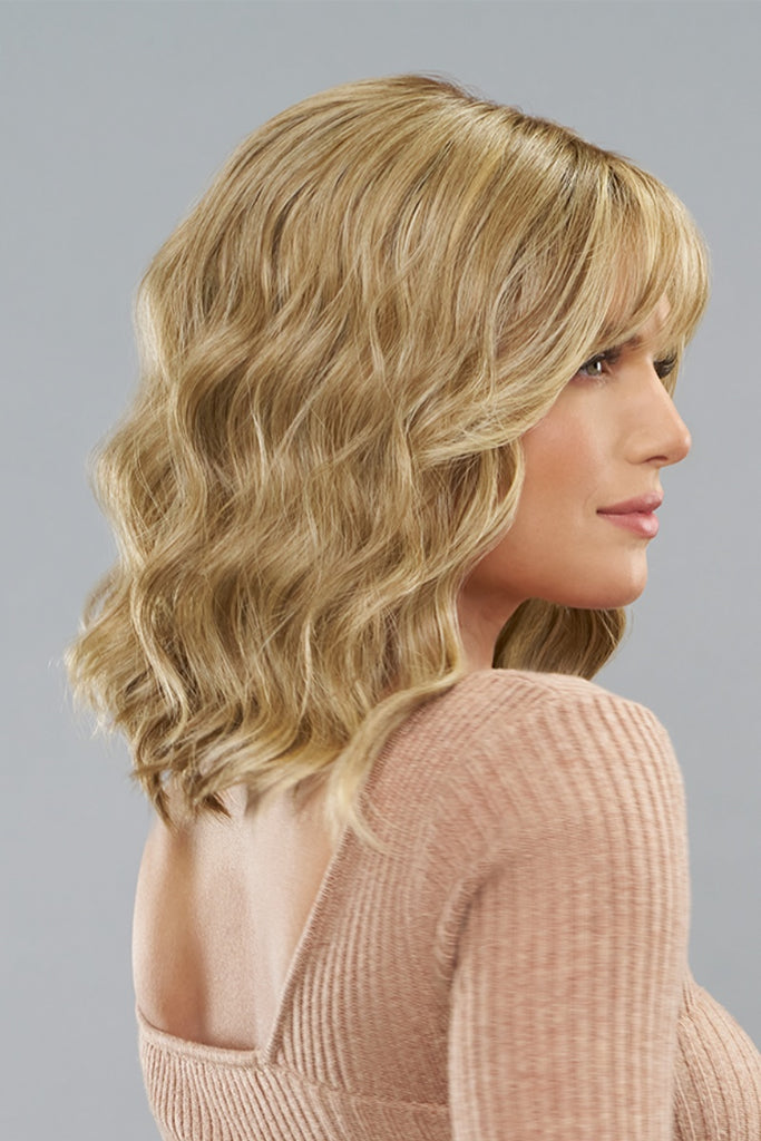 Model wearing a wavy style with bangs.