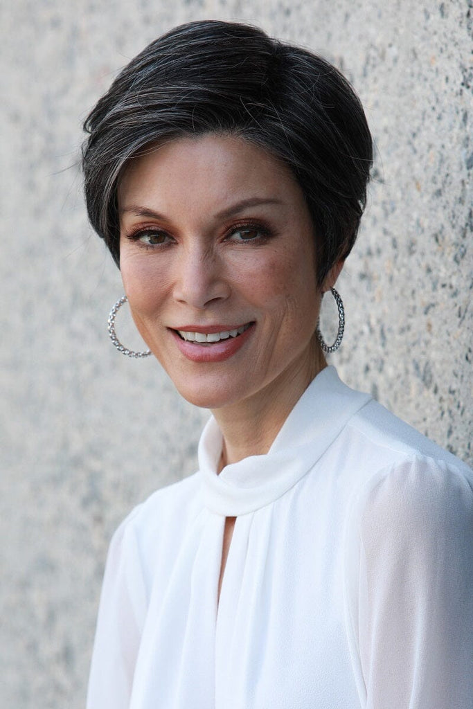 Mature woman smiling while showing off the wig Evan by Jon Renau, a short layered pixie cut.