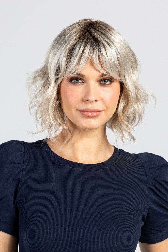 Model styling a medium length, wavy, bob wig.