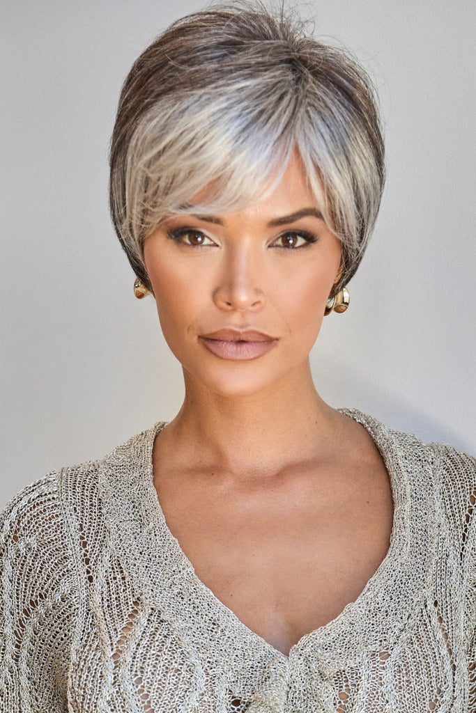 Model styling a short pixie cut wig.