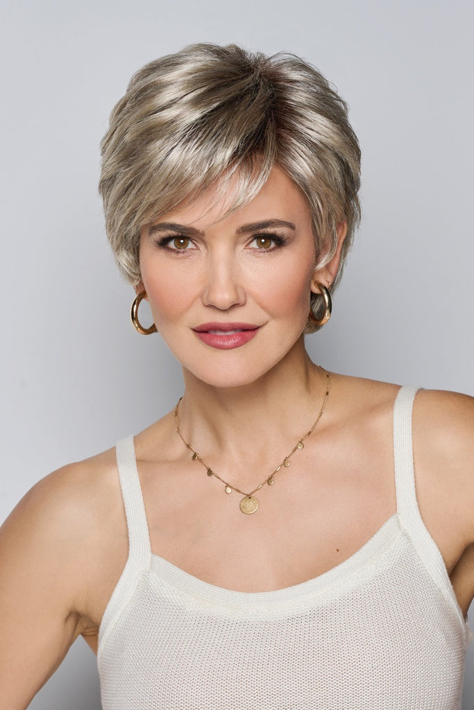 Woman styling a short multi-layered shaggy wig.