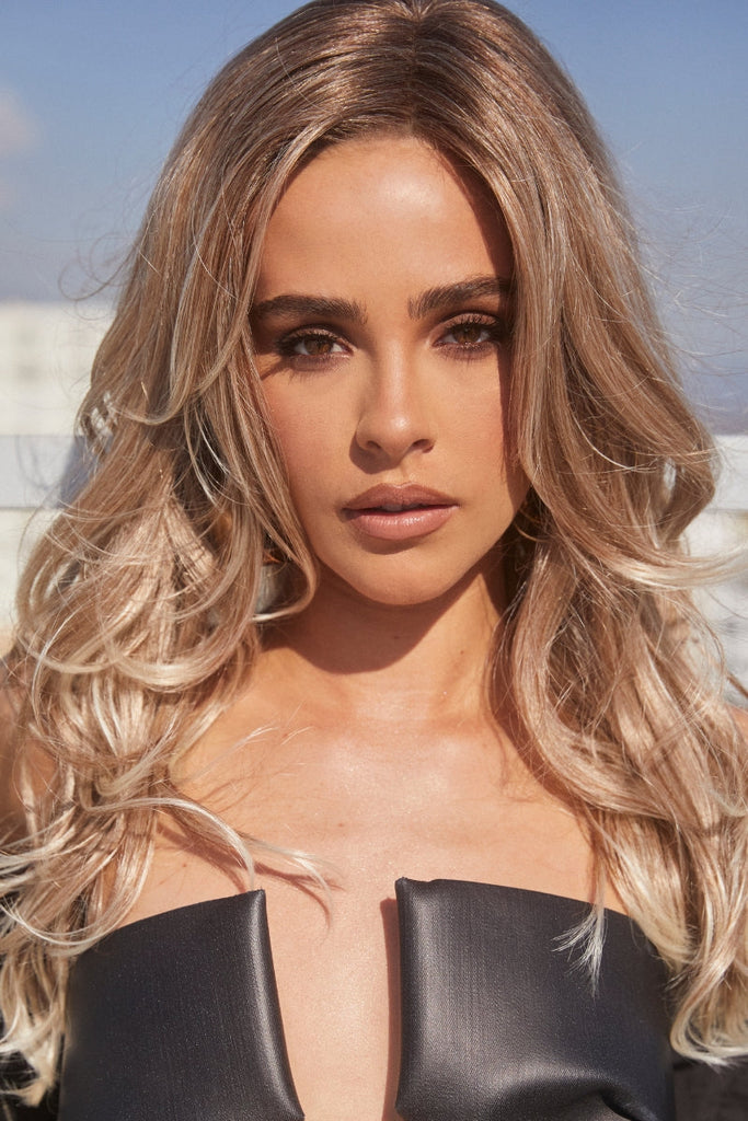 Woman modeling a dark brown rooted golden strawberry blonde wig, with a cool blonde tip - Ombre look.