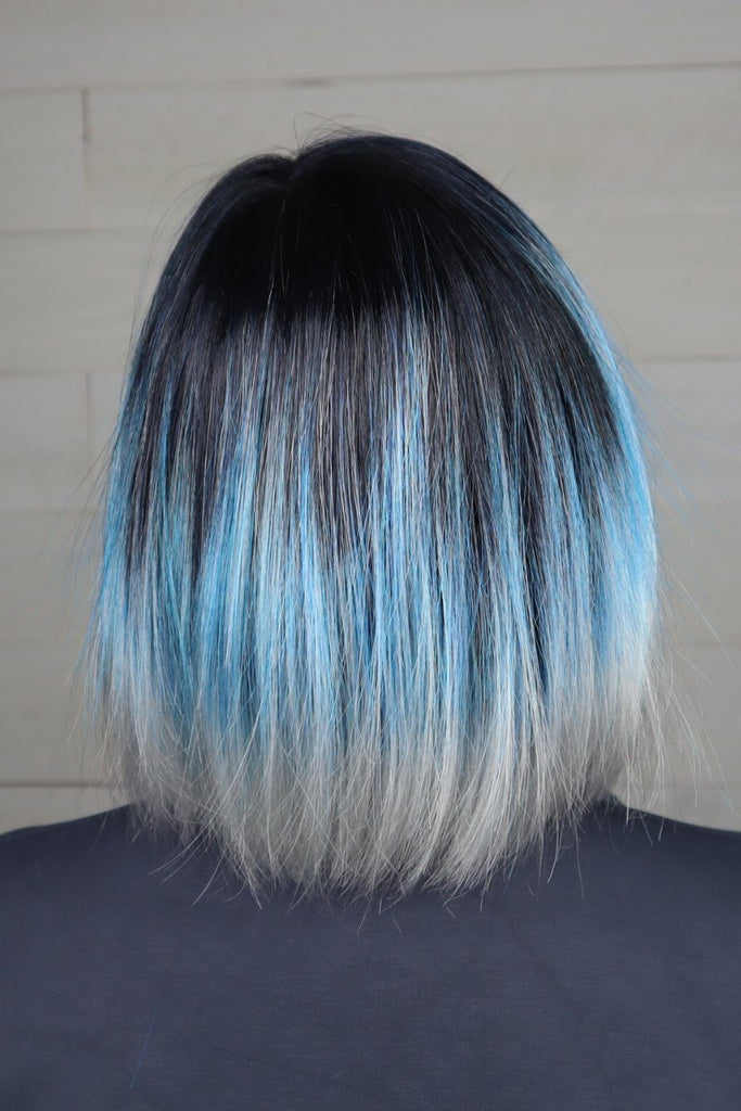 Back of woman wearing a mid-length blue wig.