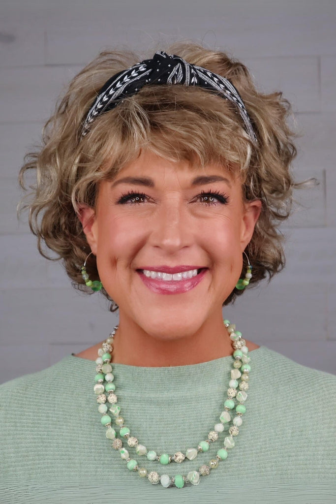 Model adding a headband into wig for added flair.