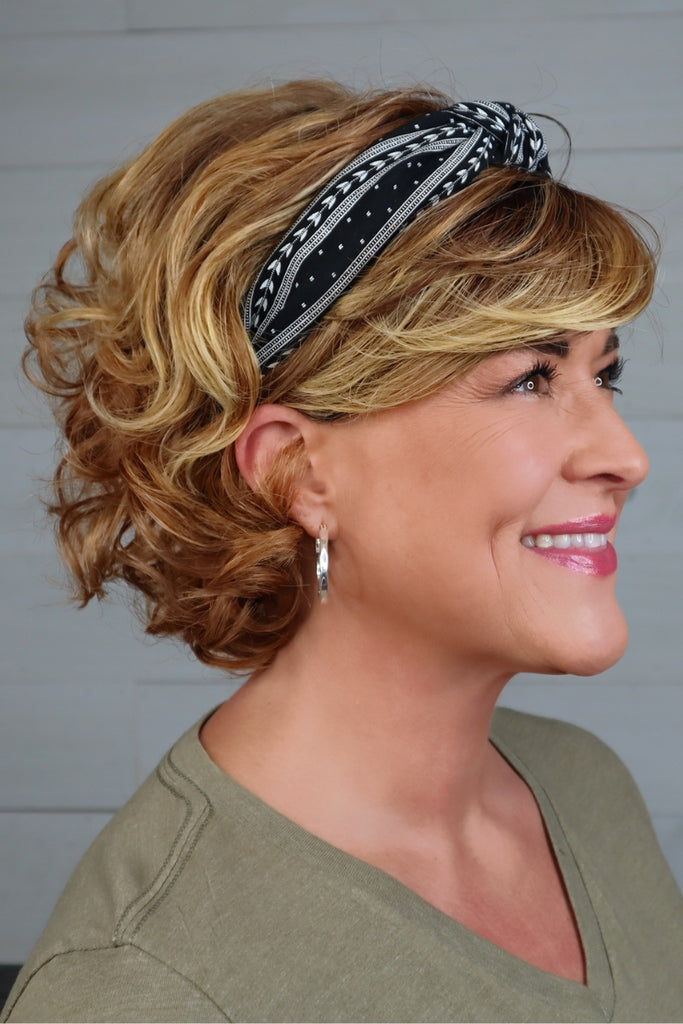 Side view of woman wearing a Red Blonde wig.