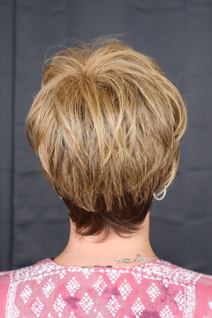 Back of model wearing a short cut pixie wig.